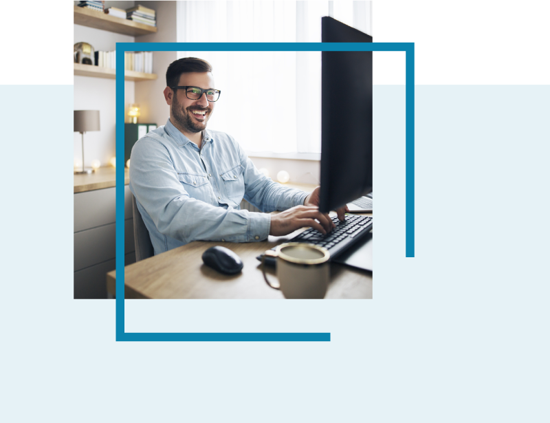 Man smiling working remotely from home sat at his computer